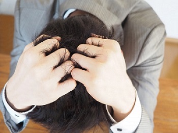 頭を抱えている男の画像